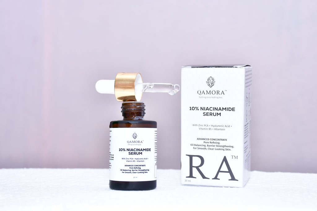 QAMORA 10% Niacinamide Serum bottle and packaging on a light purple background
